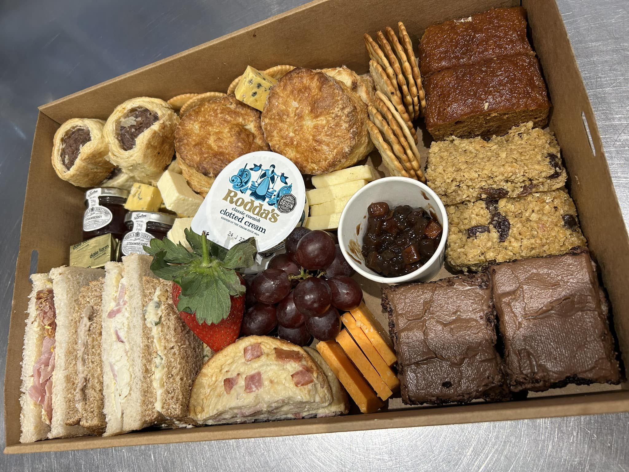 The Coniston Foodhouse afternoon tea box with sandwiches, savoury bakes, cakes, cheese, crackers and fruit